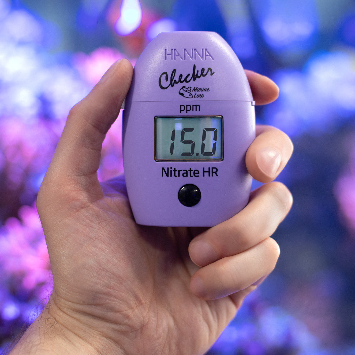 Hanna Checker HC HI782 nitrate HR held in hand in front of a reef aquarium